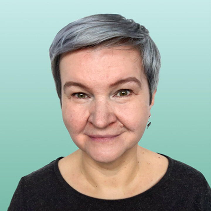 Uśmiechnięta kobieta w średnim wieku, nisi krókie, platynowe włosy.